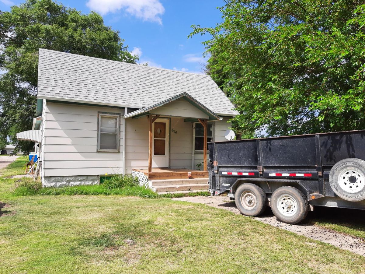 House with a trailer parked in front